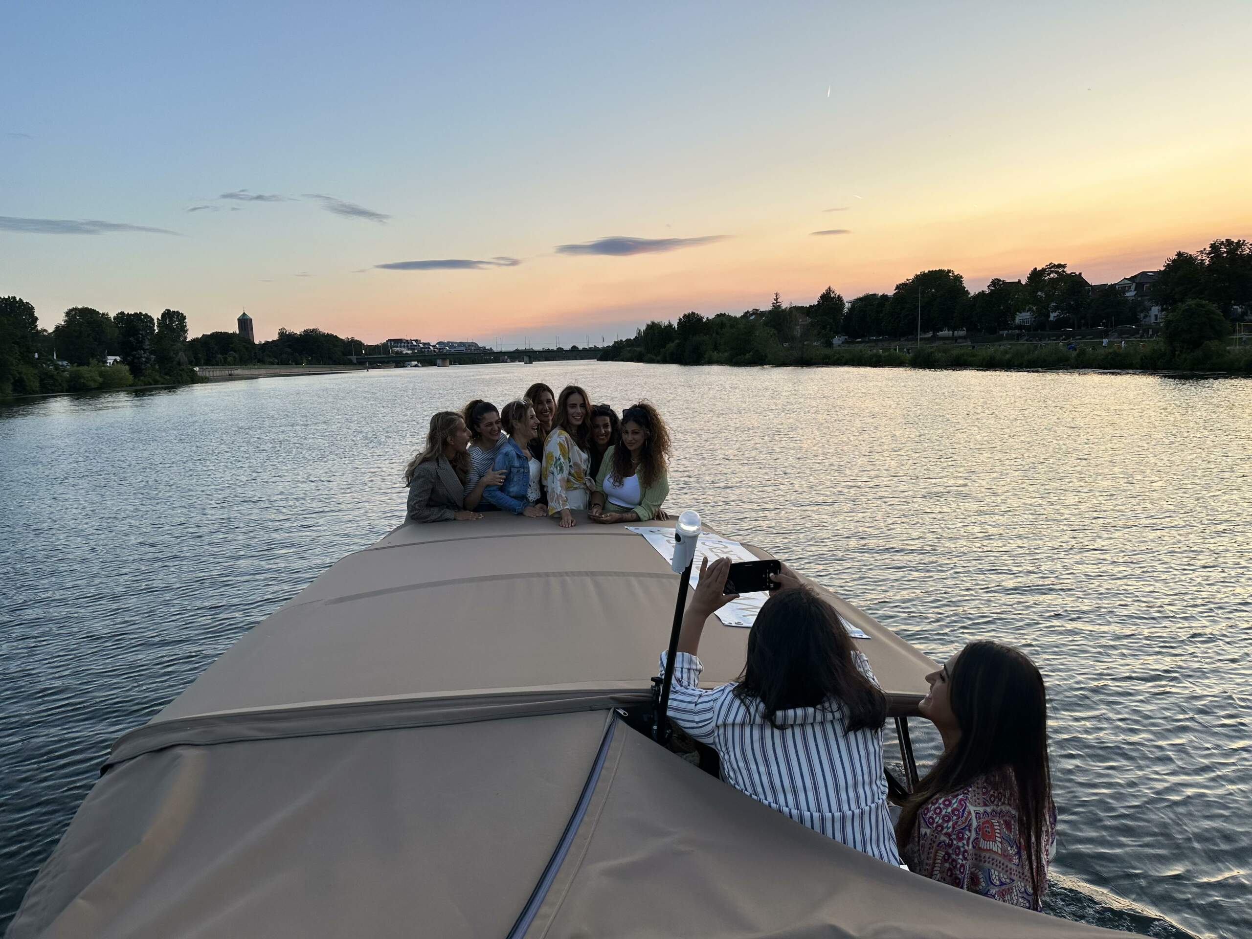Eine Gruppe von Frauen feiert Geburtstag am Boot des Riverboats, einige stehen am Bug und werden von anderen fotografiert