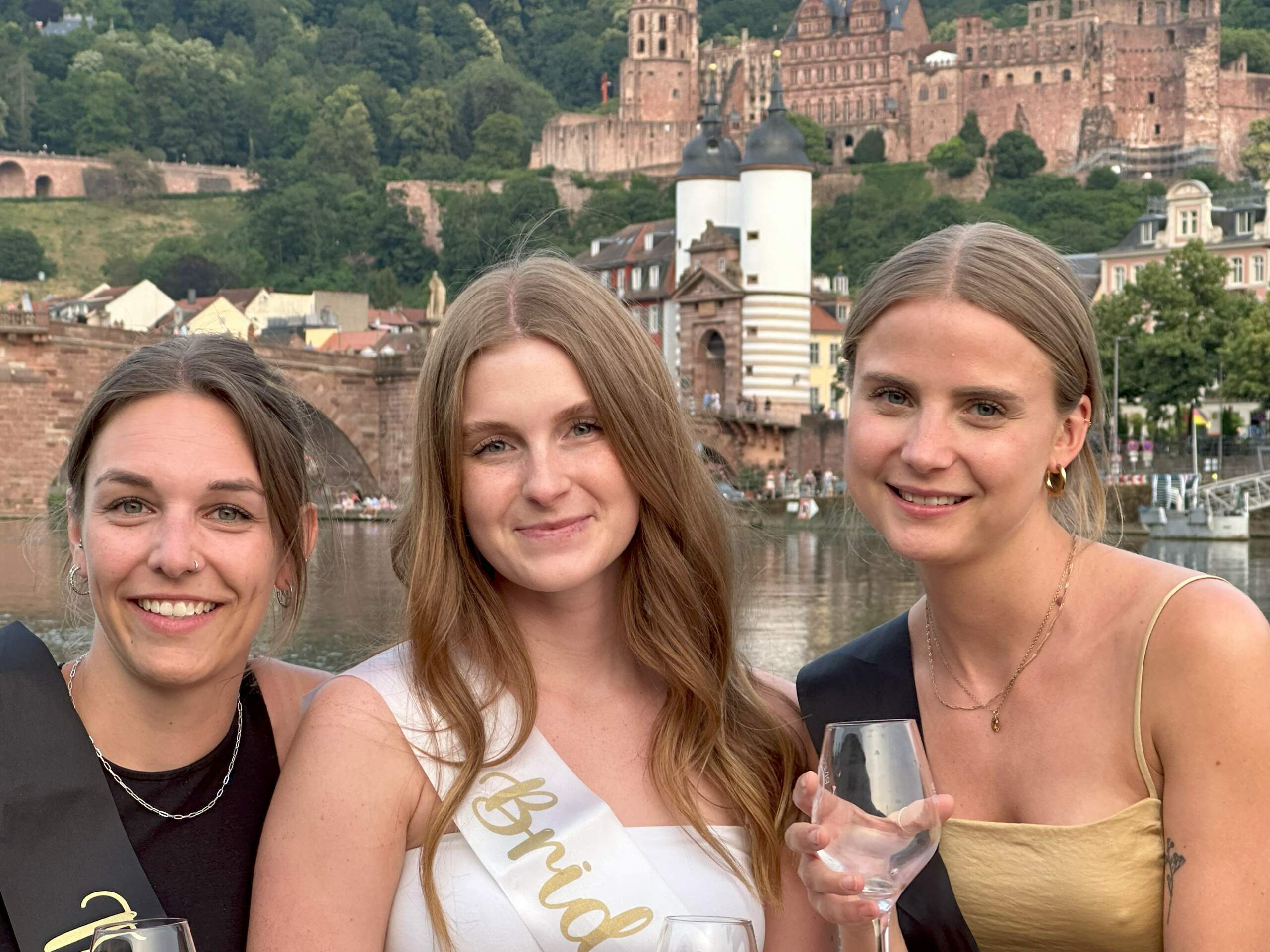 Drei Frauen feiern JGA an Bord des Riverboats mit Weingläsern in der Hand